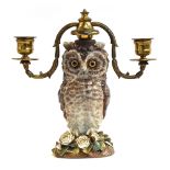 A 19th century ceramic barn owl candelabra on encrusted floral base, the owl set with glass eyes,