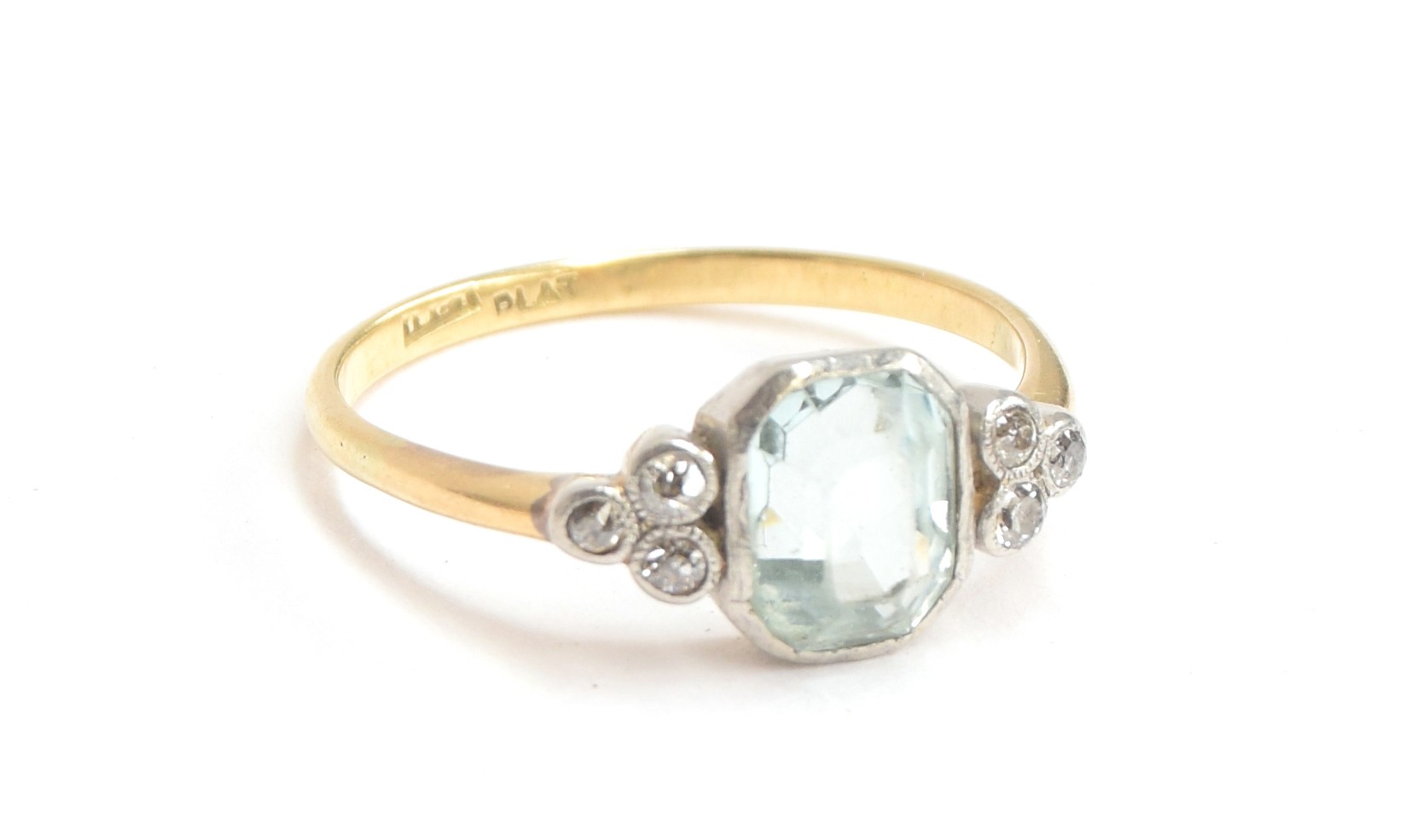 An 18ct gold and platinum ring set with a large emerald cut aquamarine between two trefoils of old