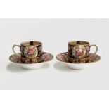 A pair of 19th century Crown Staffordshire coffee cups and saucers, hand painted with floral decorat