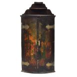 A black japanned bowfront hanging corner cabinet, 18th century, painted with a biblical scene,