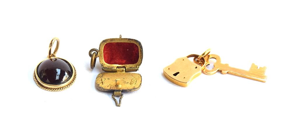 A 14ct gold pendant set with a garnet cabochon, 1.4cm long; together with a yellow metal padlock and - Image 3 of 3