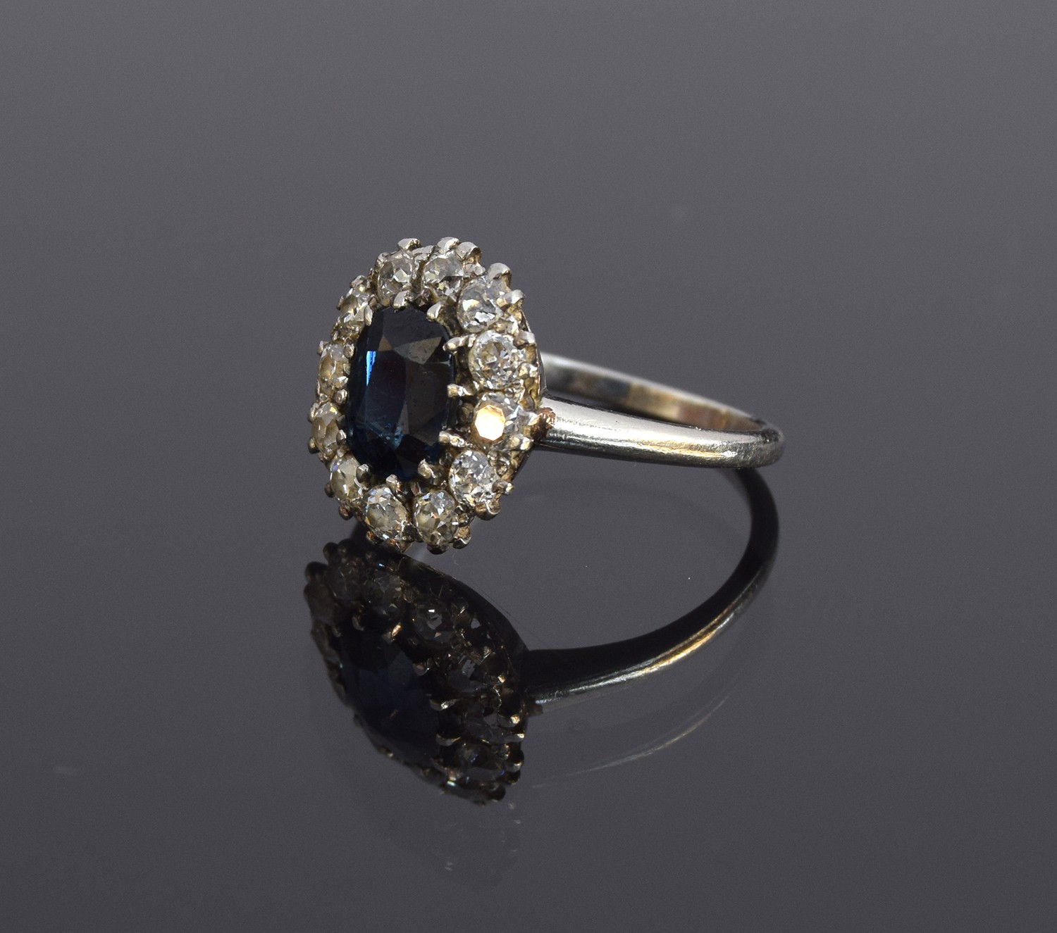 An early 20th century platinum, sapphire and diamond cluster ring, the central mixed cut sapphire - Image 2 of 3