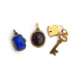A 14ct gold pendant set with a garnet cabochon, 1.4cm long; together with a yellow metal padlock and