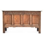 An early 18th century four panel oak coffer, carved with initials WH, 134cm wide, 52cm deep, 76cm
