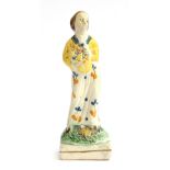 A late 18th century Staffordshire pottery figure of a woman holding a basket of flowers, 15.5cm high