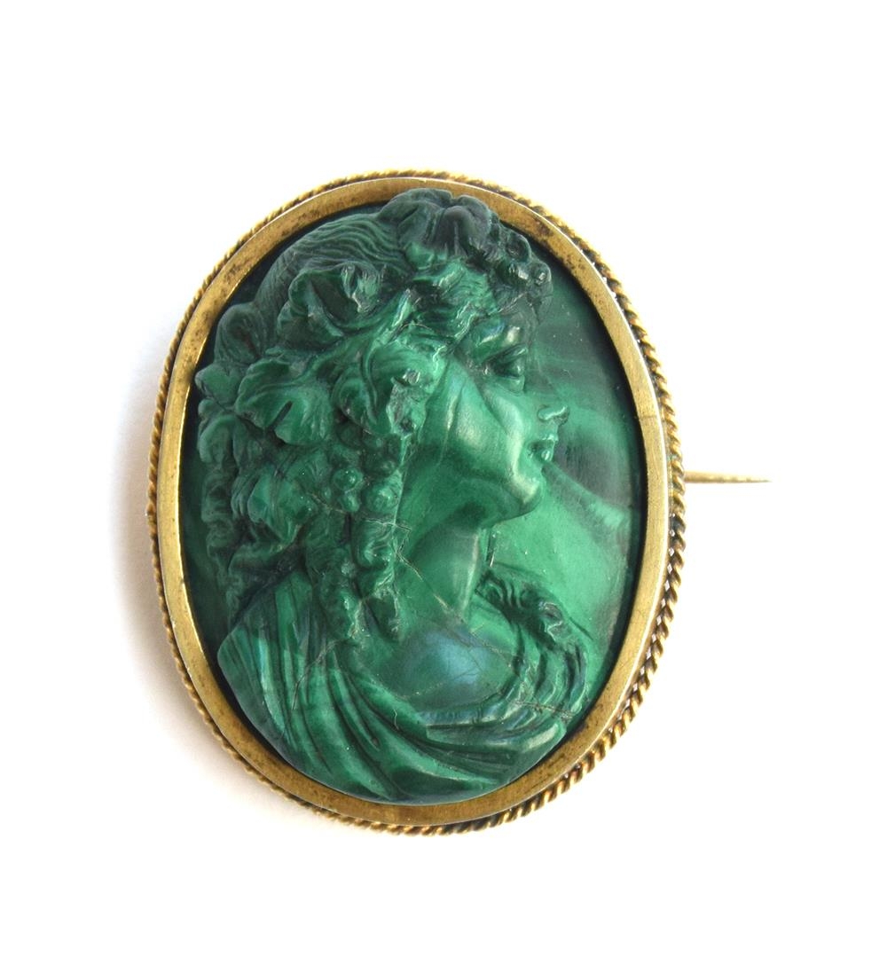 A late Victorian high relief carved malachite cameo of a Bacchante, mounted in silver gilt with a