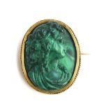 A late Victorian high relief carved malachite cameo of a Bacchante, mounted in silver gilt with a