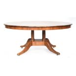 A contemporary bespoke made walnut circular dining table, on a four column base with swept legs