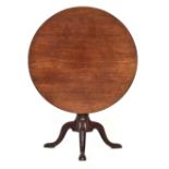 A George III mahogany tripod table, tip-top with birdcage action, gun barrel column support on three