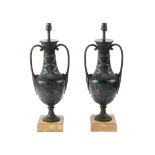 A pair of patinated metal models of classical urns, 20th century and later fitted for electricity,