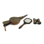 An arts and crafts style hand mirror with bevelled glass; fire bellows; and a pair of binoculars