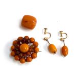 A pair of yellow metal and amber bead screw back earrings (one bead chipped), 2.3g; together with an