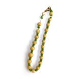 A russet jade and green glass bead necklace in need of restringing