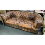 A brown leather upholstered chesterfield button back sofa, with tears and wear, 205cmW