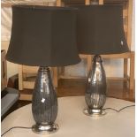 A pair of silvered glass table lamps, with black shades, height to top of shade 80cmH