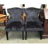 A pair of modern black velour upholstered armchairs