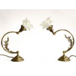 A pair of gilt metal articulated table lamps with foliate detail and frosted glass floral shades,