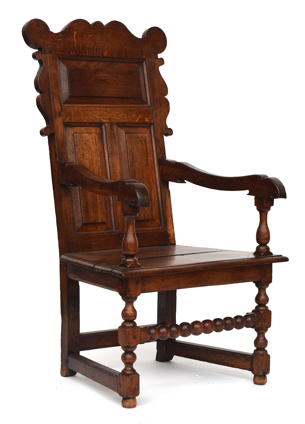 An 18th century oak wainscot chair, shaped cresting rail, over a panelled back, turned uprights