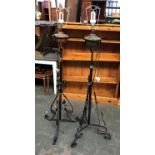 Two wrought iron standing oil lamps converted for electricity, with shades, each approx. 130cmH to