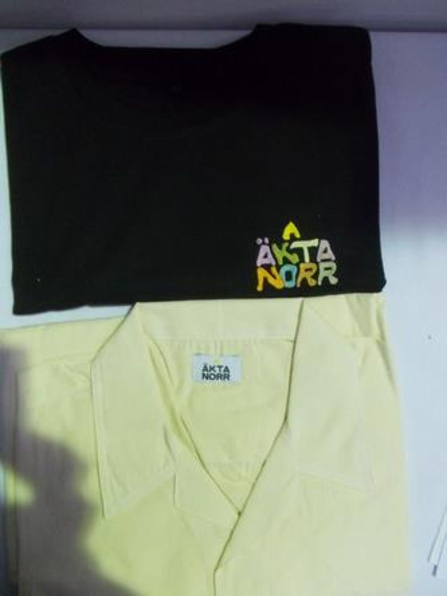 2 x items of Akta Norr men's clothing comprising 1 x black logo t-shirt, size L and 1 x oversized