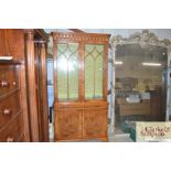 A reproduction yew wood china display cabinet on c