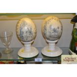 Two scrimshaw ostrich eggs on stands