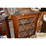 An antique oak hanging corner display cabinet