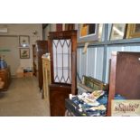 A reproduction mahogany standing corner cupboard