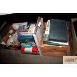 A box of various books and stack of puzzles and ga