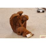 A cast iron figure of a sleeping angel, measuring approximately 10 inches long X 8 3/4 inches high X