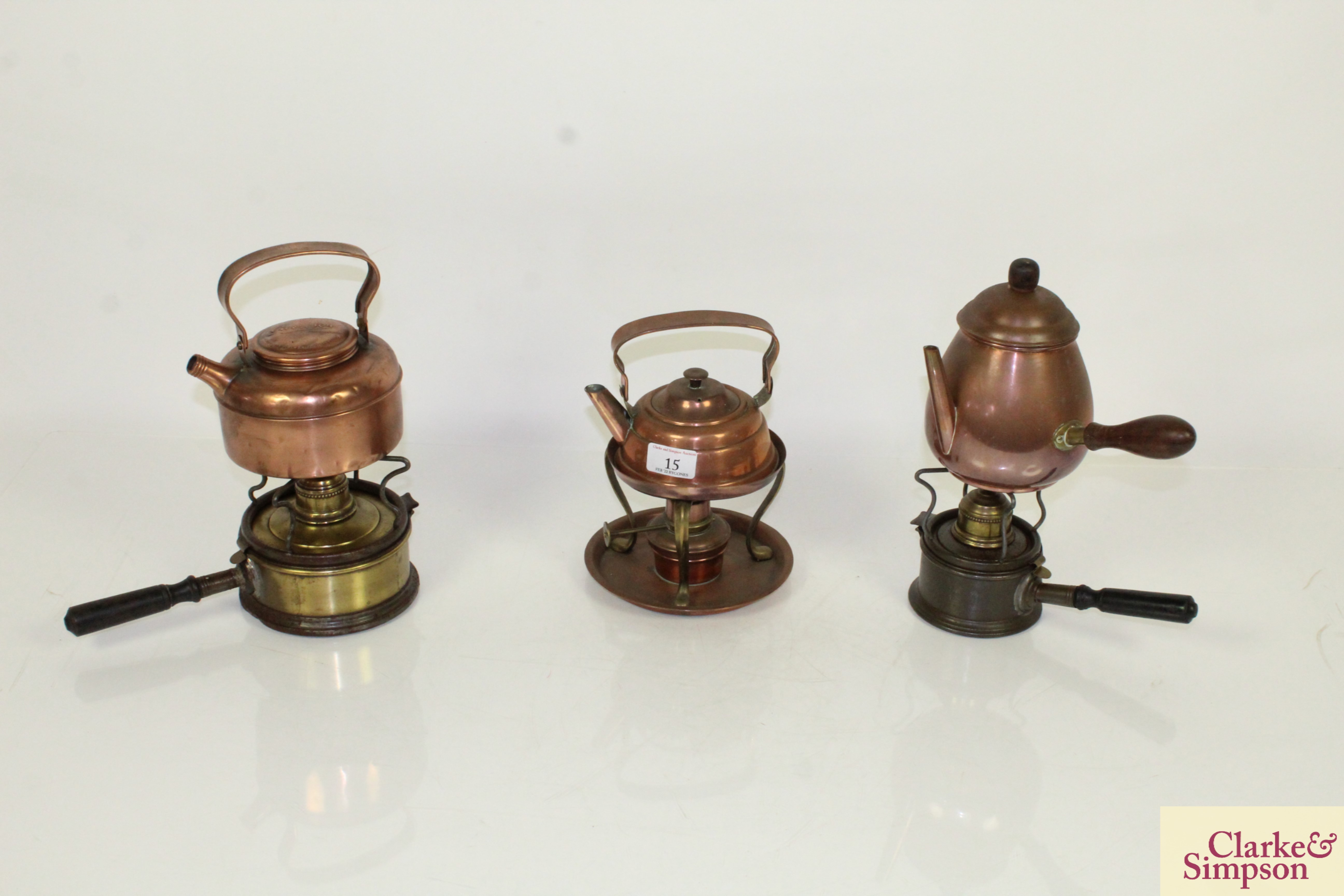 Three various copper and brass kettles on spirit he