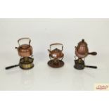 Three various copper and brass kettles on spirit he