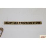 A small brass "Dairy Use Provision Store" sign app
