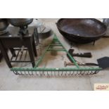 A large green painted drag rake