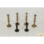 Two pairs of brass candlesticks and a pair of wood