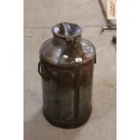 A tall metal ware milk churn