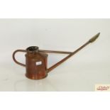 A copper watering can with brass rose