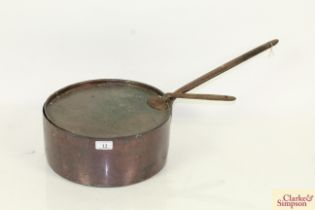 An antique copper saucepan and lid with cast iron