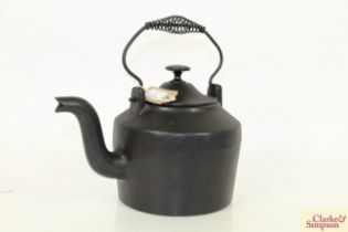 A vintage cast iron kettle with swing handle