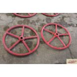 A pair of red painted heavy iron wheels