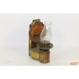 An antique copper and brass wall mounting oil lamp