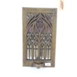 A mural type candle holder with Gothic style pierced decoration and mirrored backing