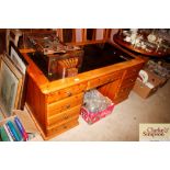 A modern pine pedestal desk with inset plate glass