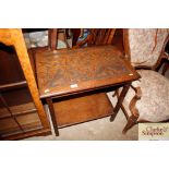 A carved oak two tier side table