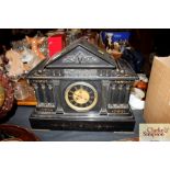 A Victorian black slate mantel clock in architectu