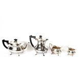 A silver four piece tea set, Hallmarked for Birmingham 1937, the teapot and hot water jug with black