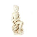 A 19th Century French Parianware figure, of a young scantily clad female seated on rocks, 22cm high