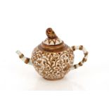 A Chinese brown glazed pottery teapot, the lid surmounted by a bird finial, bamboo shaped handle and