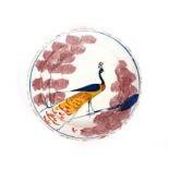 A rare Bristol Delft farmyard plate, with a peacock displaying in blue, yellow and ochre between