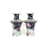 A pair of Chinese baluster vases, profusely decorated blossom on a blue ground, seal marks to